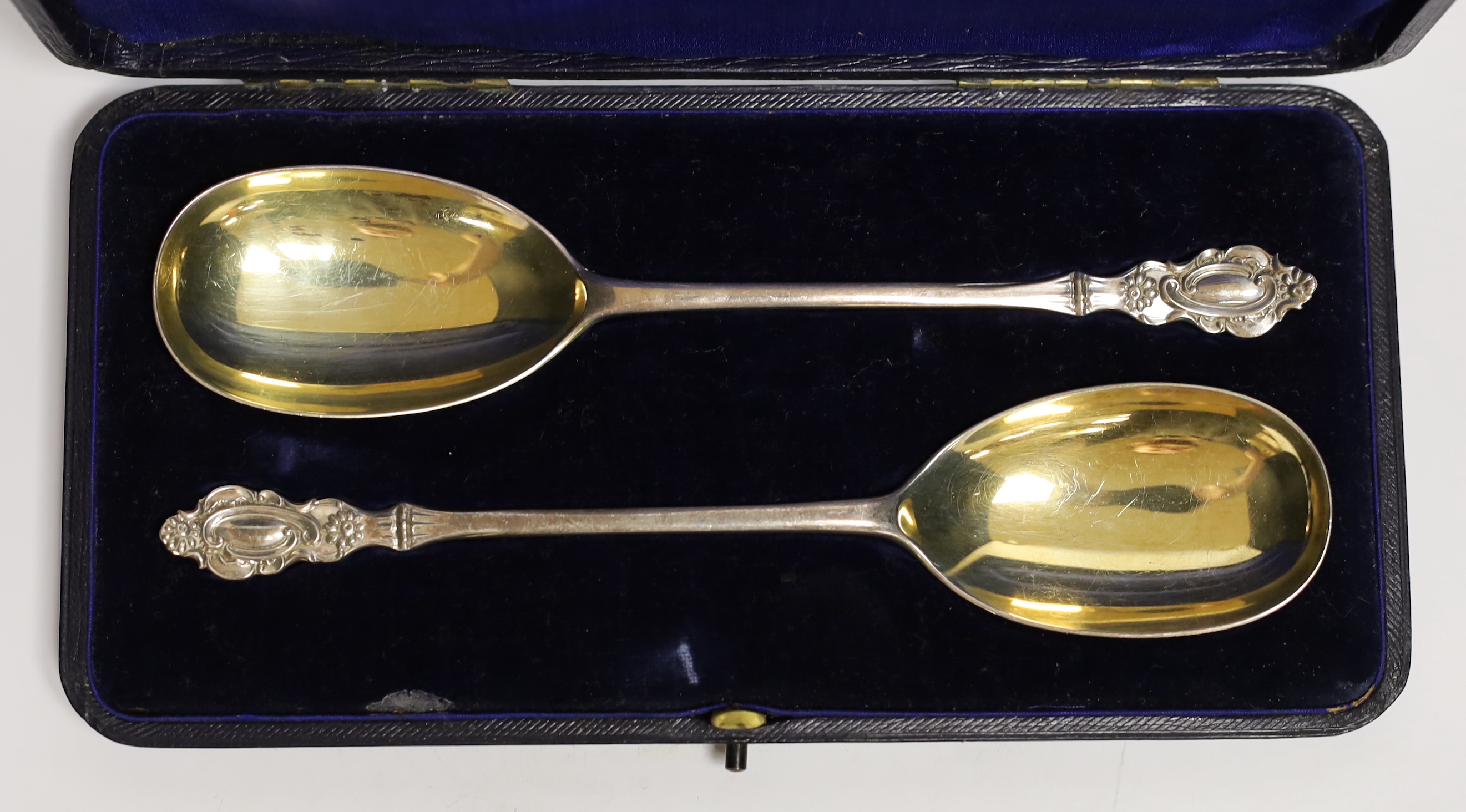A cased pair of Edwardian parcel gilt silver serving spoons, Josiah Williams & Co Ltd, London, 1906, 19.6cm.